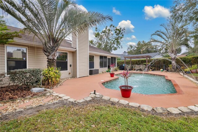 view of swimming pool featuring pool water feature, central AC unit, and a patio