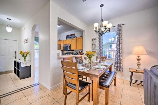 tiled dining space featuring a chandelier