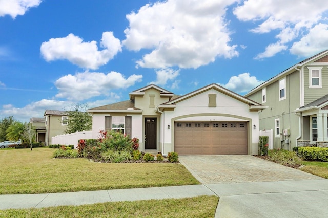 2232 Donahue Dr, Ocoee, FL 34761 - view of front of house with stucco siding, driveway, an attached garage, and a front lawn
