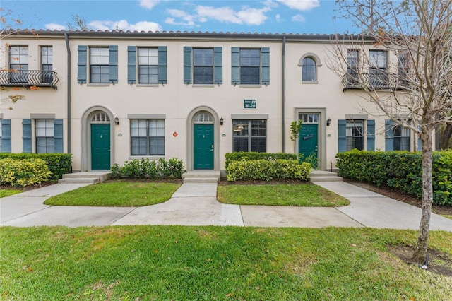 townhome / multi-family property featuring a front lawn