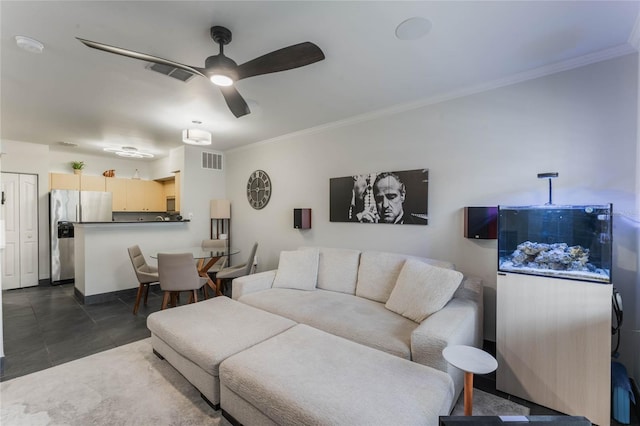 tiled living room featuring ceiling fan and ornamental molding