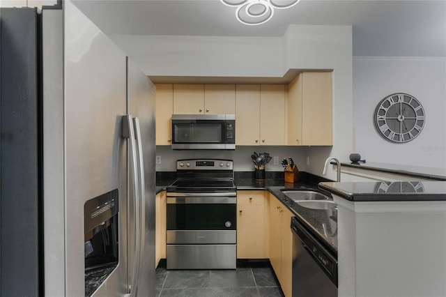 kitchen with kitchen peninsula, appliances with stainless steel finishes, light brown cabinetry, dark tile patterned flooring, and sink