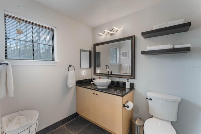 bathroom featuring toilet, vanity, and tile patterned flooring