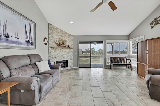 living room with ceiling fan, lofted ceiling, and a fireplace