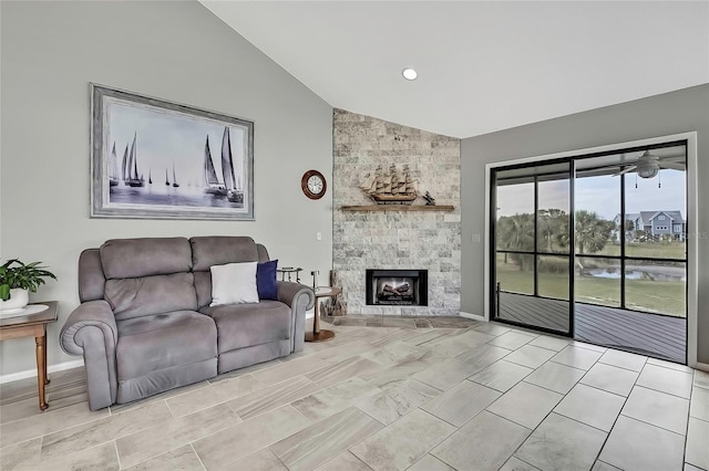 living room with ceiling fan, lofted ceiling, and a stone fireplace