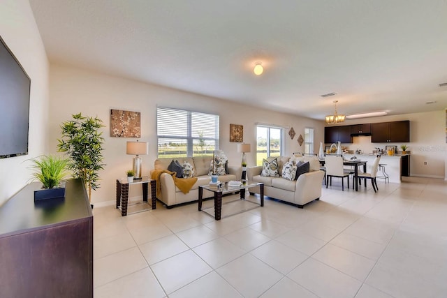 living room with light tile patterned floors and an inviting chandelier