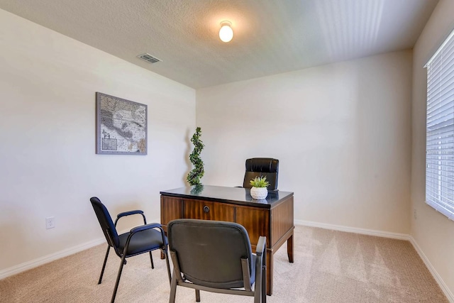 home office featuring light carpet and a textured ceiling