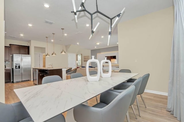 dining room with sink and light hardwood / wood-style flooring