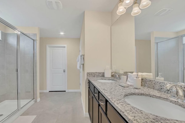 bathroom with vanity, a shower with shower door, and tile patterned floors