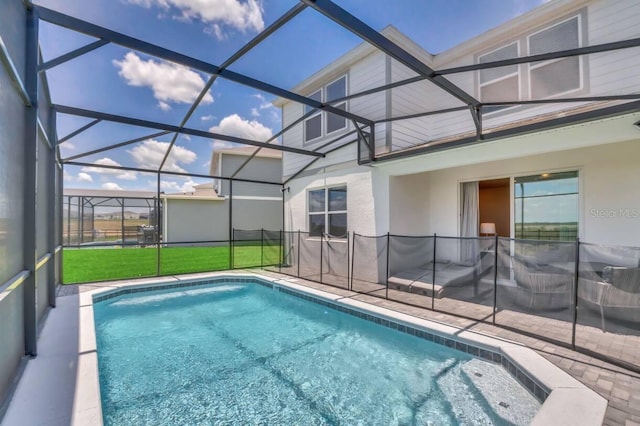 view of pool with a lanai, a patio, and a lawn