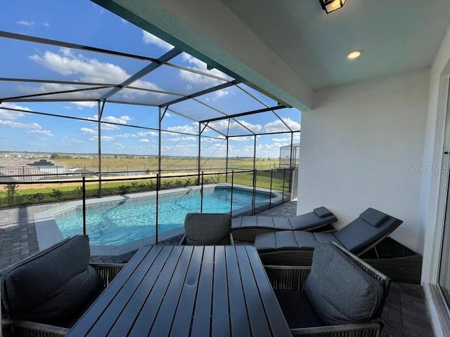 view of swimming pool featuring a patio and glass enclosure