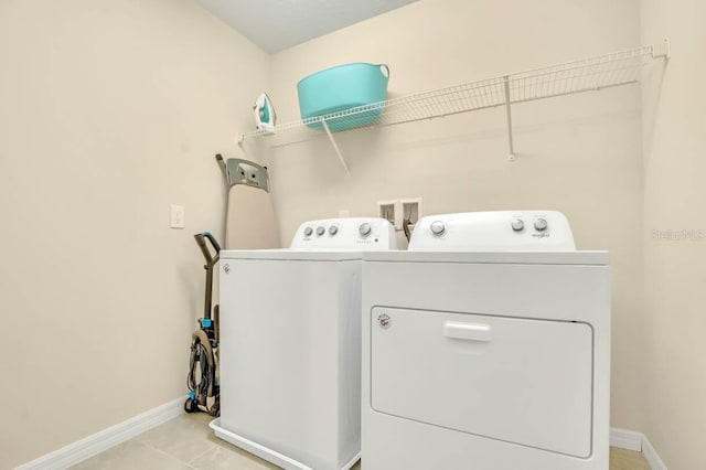 laundry area featuring light tile patterned floors and washing machine and clothes dryer