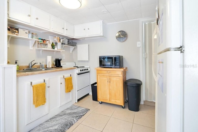 kitchen with white cabinets, white range with electric cooktop, sink, and light tile patterned floors