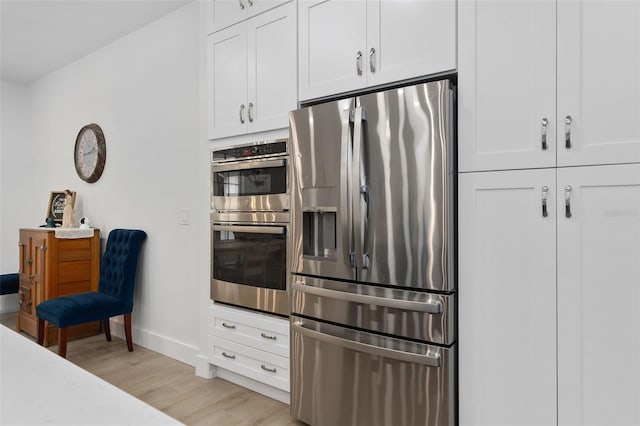 kitchen with white cabinetry, light hardwood / wood-style flooring, and appliances with stainless steel finishes