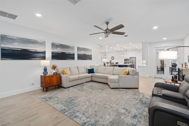 living room with ceiling fan and light hardwood / wood-style flooring