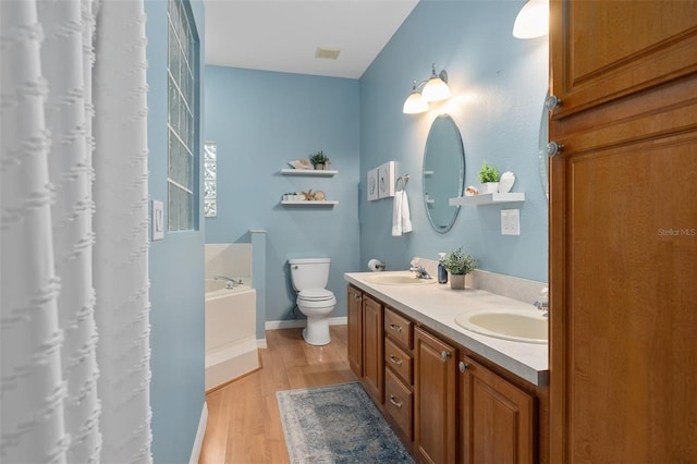 bathroom with vanity, a bathtub, wood-type flooring, and toilet