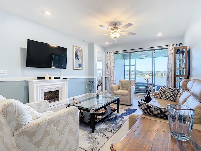 living room with ceiling fan and a premium fireplace