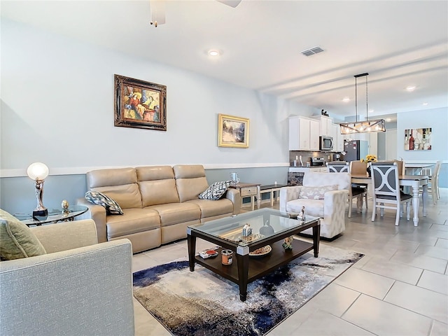 tiled living room featuring a notable chandelier