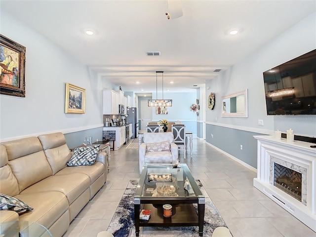 tiled living room with a notable chandelier