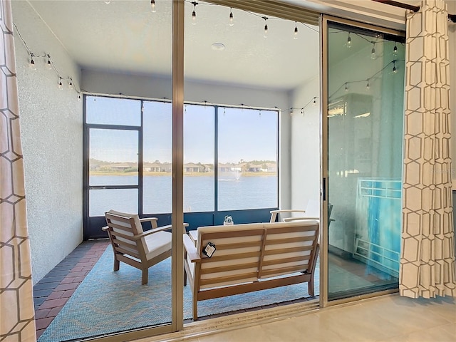 sunroom / solarium featuring a water view