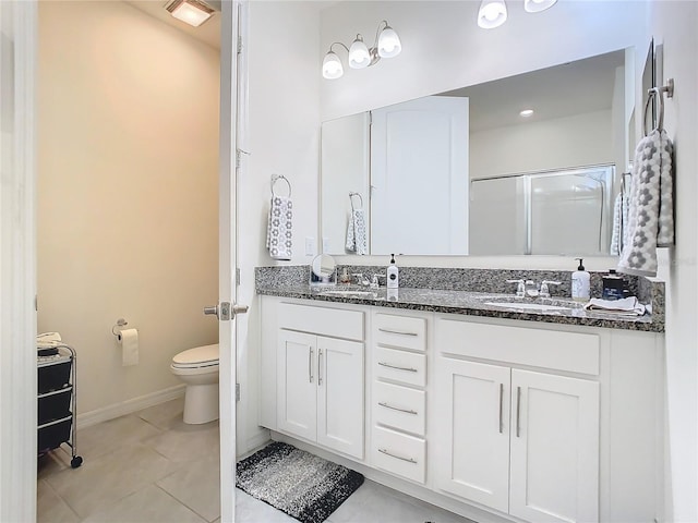 bathroom featuring toilet, tile patterned floors, an enclosed shower, and vanity