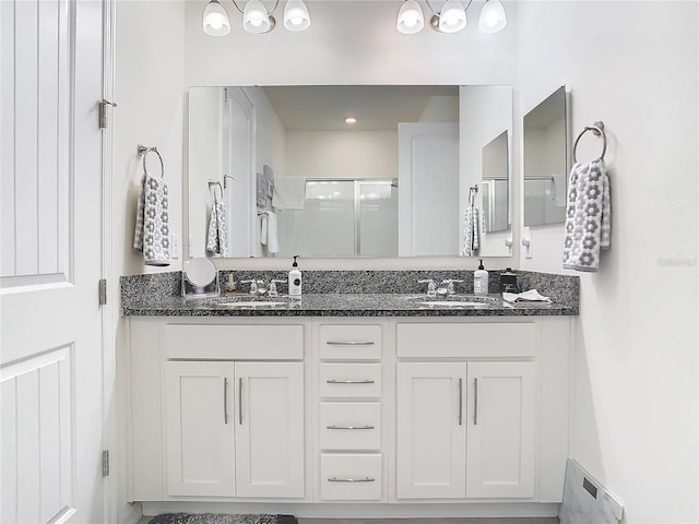 bathroom with a shower with door and vanity