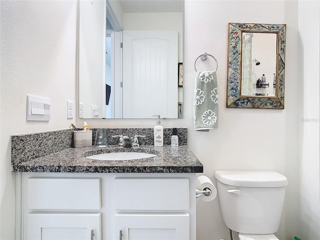 bathroom featuring toilet and vanity