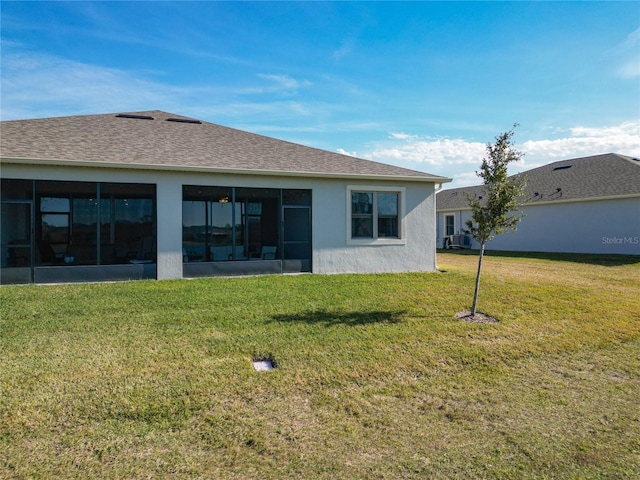 back of house featuring a yard and a sunroom