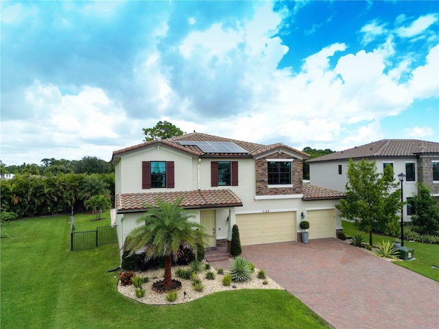 mediterranean / spanish home with a front lawn, a garage, and solar panels