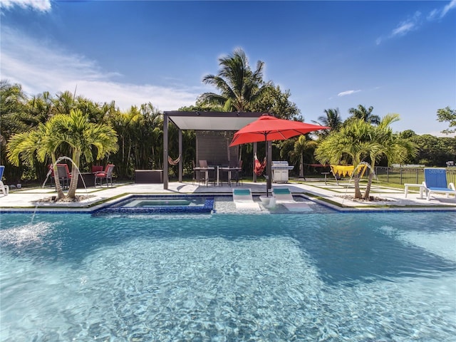 view of swimming pool with a jacuzzi, pool water feature, and a patio