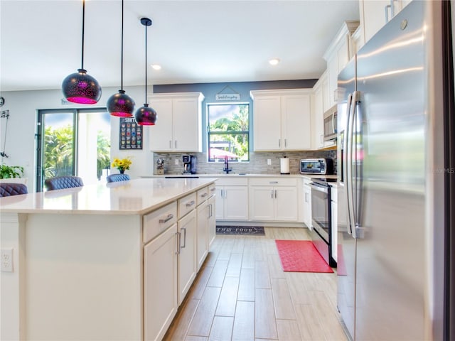 kitchen with white cabinetry, stainless steel appliances, tasteful backsplash, pendant lighting, and a center island