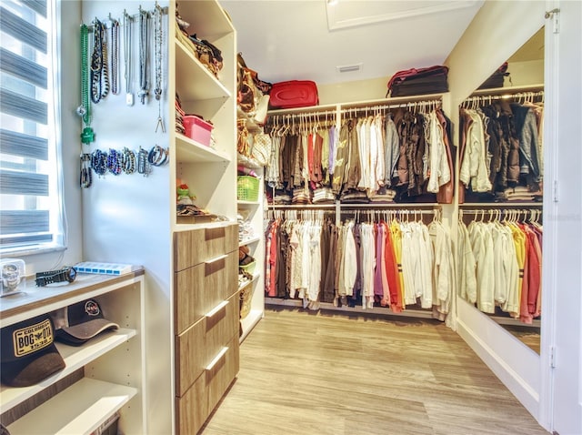 walk in closet with light hardwood / wood-style flooring