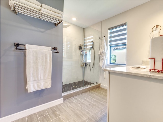 bathroom with tiled shower and vanity