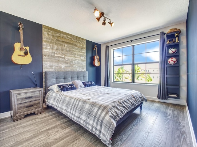 bedroom featuring wood-type flooring and a textured ceiling