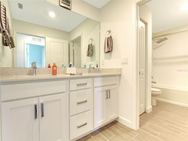 full bathroom with toilet, tiled shower / bath, and vanity