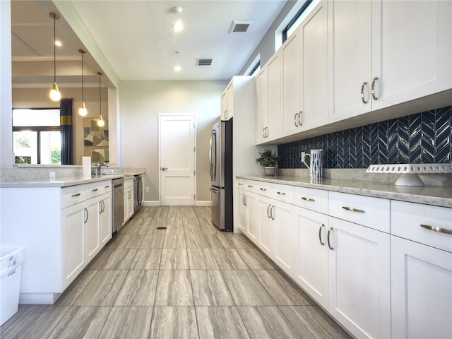 kitchen with decorative light fixtures, tasteful backsplash, stainless steel appliances, and white cabinetry