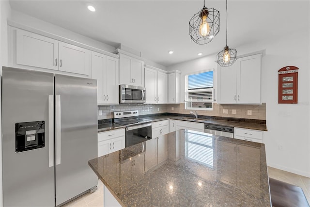 kitchen featuring white cabinets, stainless steel appliances, and dark stone countertops