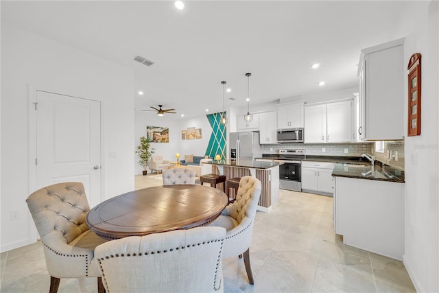 dining room with ceiling fan and sink