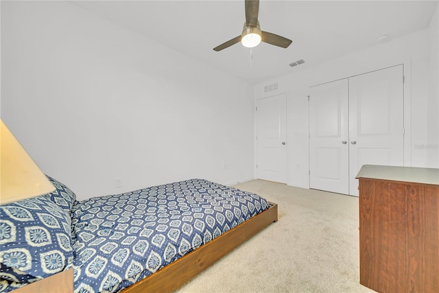 bedroom featuring ceiling fan, a closet, and light carpet