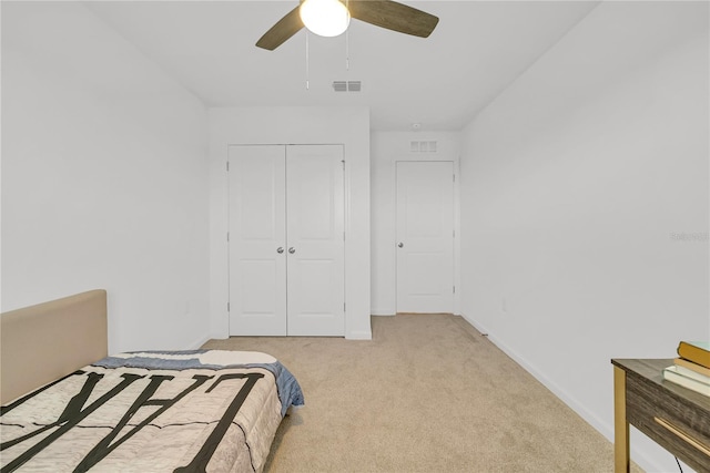 bedroom featuring ceiling fan, a closet, and light carpet