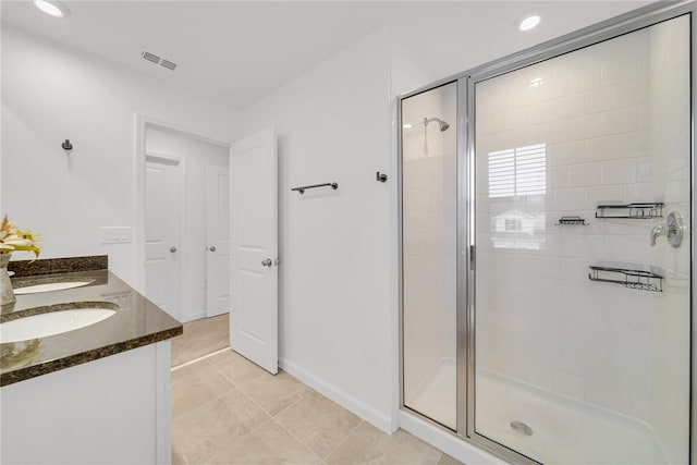 bathroom with tile patterned floors, a shower with shower door, and vanity