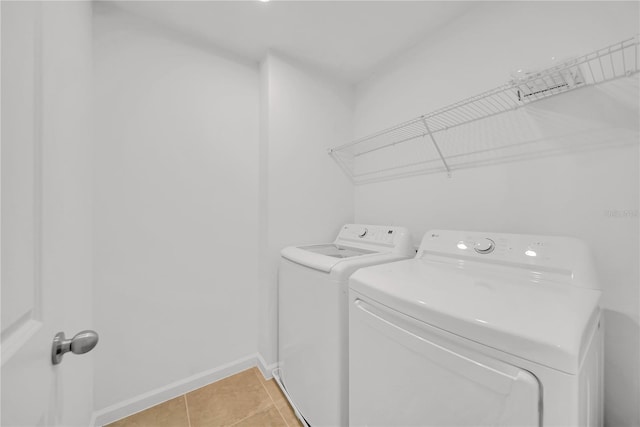 washroom with light tile patterned floors and washer and dryer