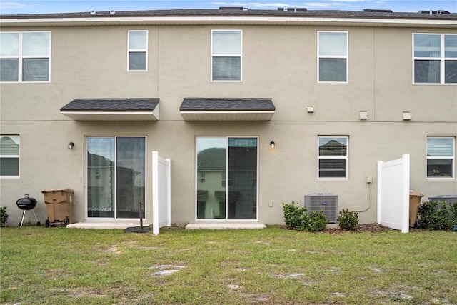 back of house featuring central AC unit and a yard