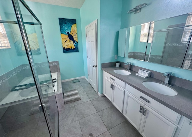 bathroom featuring a shower with shower door, vanity, and tile patterned floors