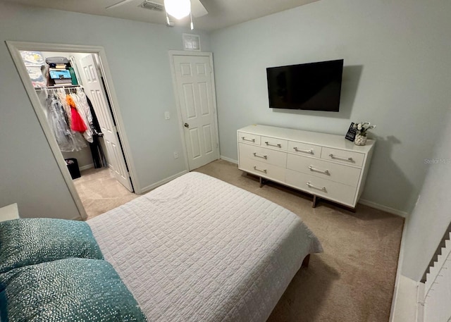 carpeted bedroom featuring ceiling fan, a spacious closet, and a closet