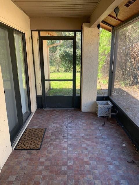 unfurnished sunroom with wood ceiling and visible vents