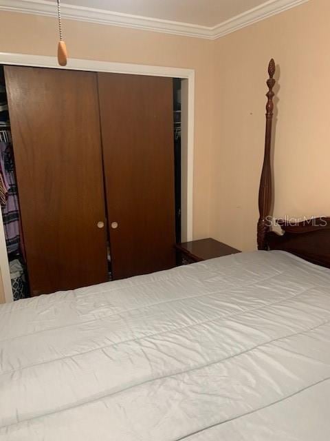 unfurnished bedroom featuring ornamental molding and a closet