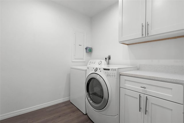 laundry area featuring dark wood-type flooring, washer and clothes dryer, electric panel, and cabinets