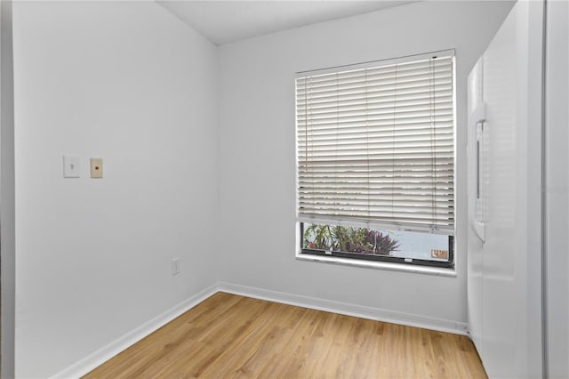 unfurnished room with baseboards and wood finished floors