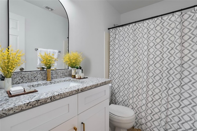 bathroom featuring a shower with curtain, visible vents, vanity, and toilet